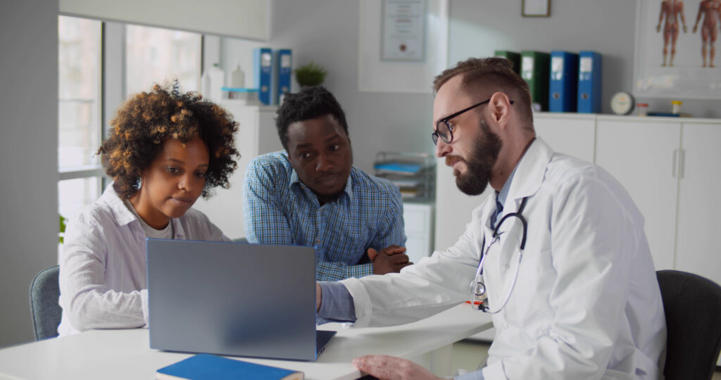 Kinderwunschpaar mit einem Kinderwunscharzt beim Erstbesuch in einer Kinderwunschklinik
